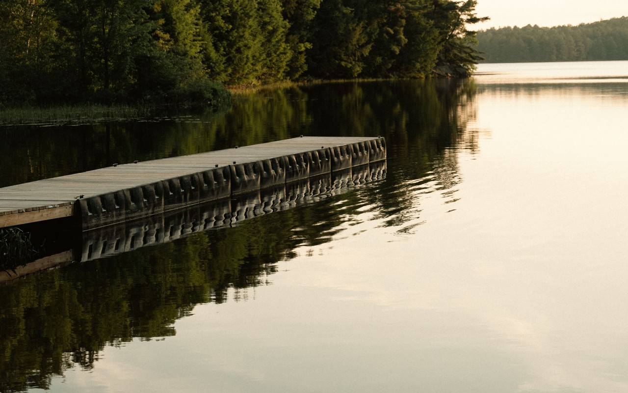 A floating dock on a calm lake at sunset