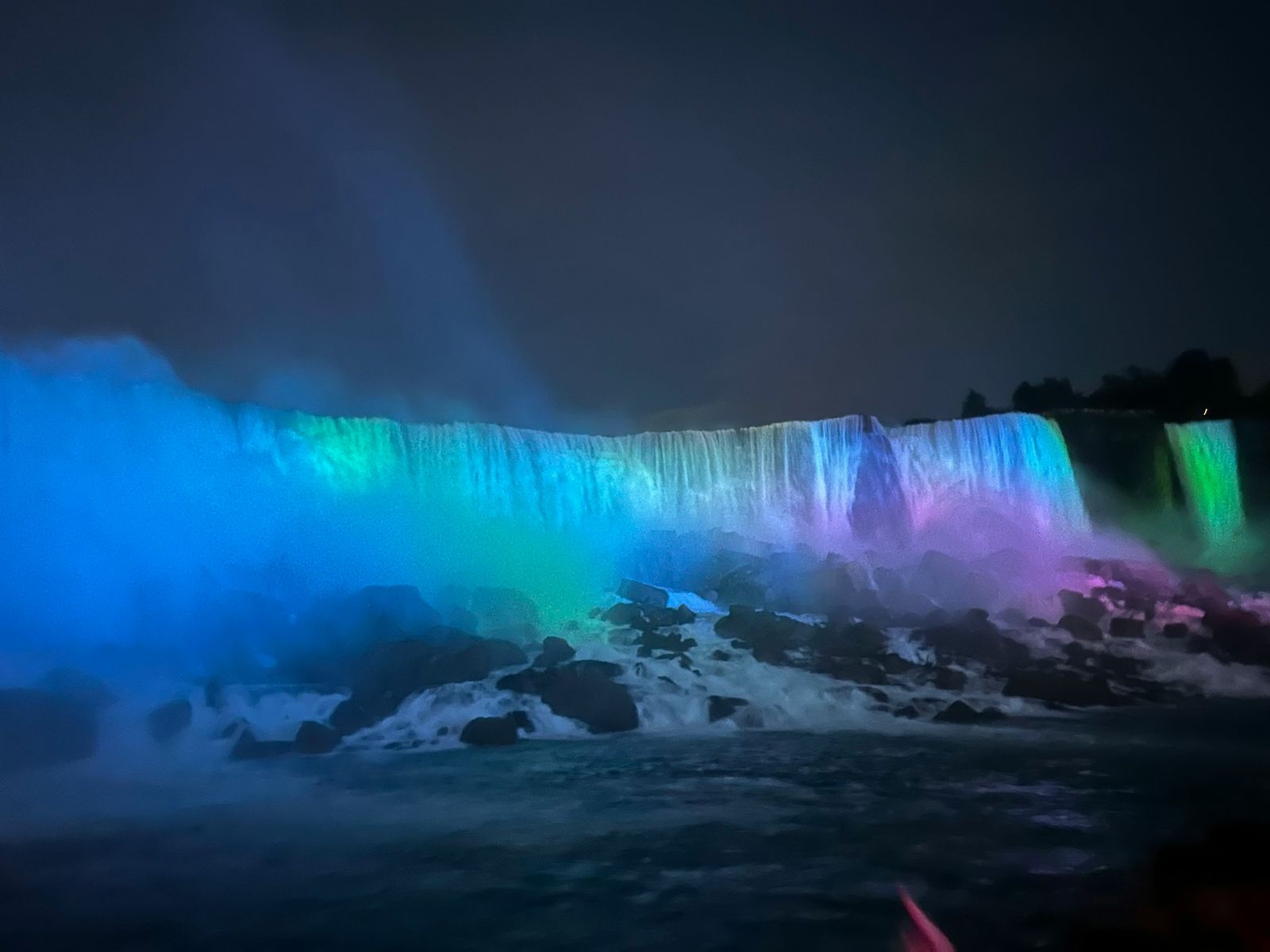 Niagara Falls lit in blue, green and purple at night