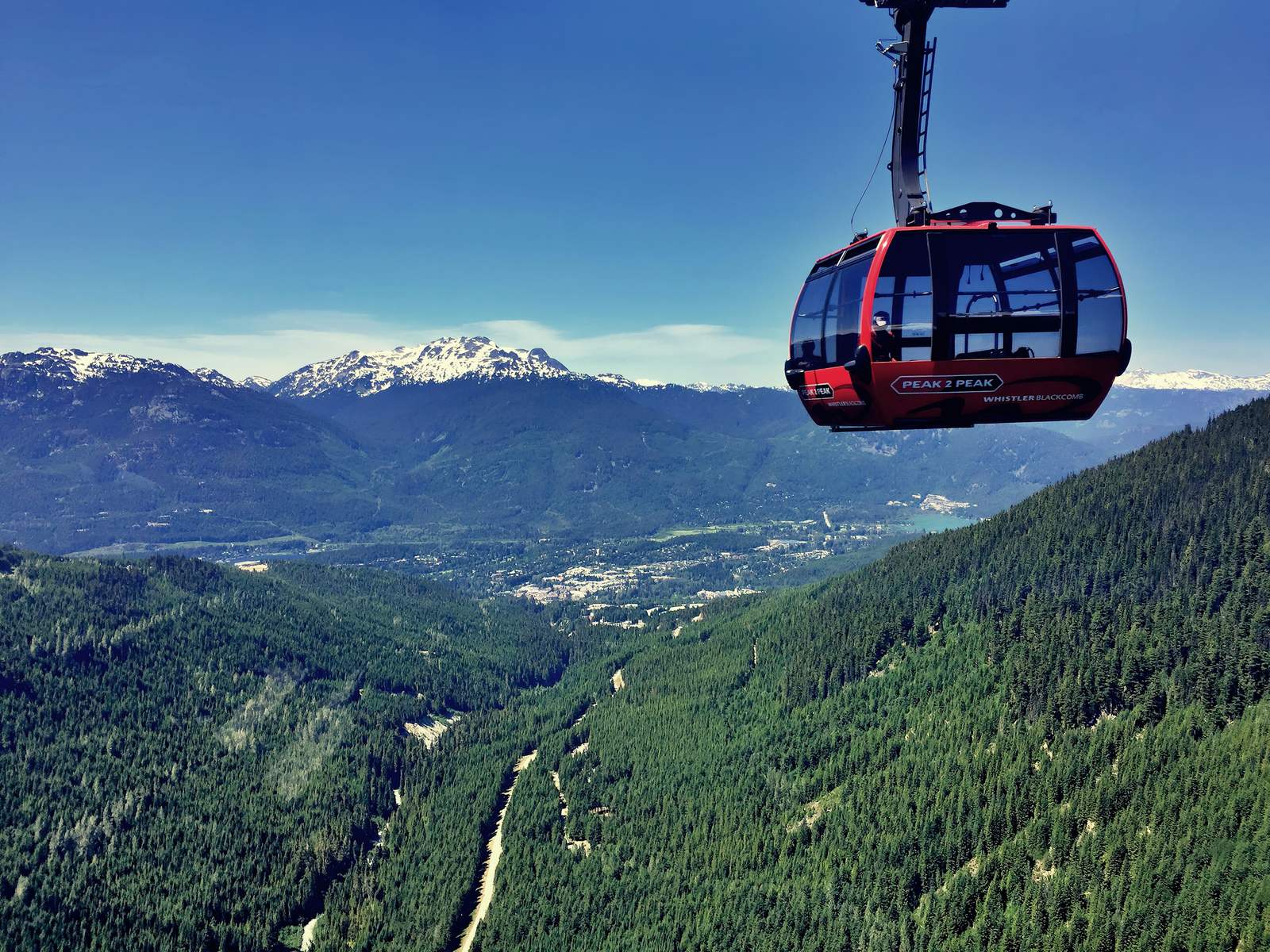 The Peak 2 Peak gondola above the Whistler valley with snow-capped mountains behind